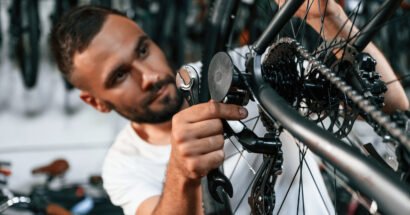 Checking the wheel and brake system. Repair man in bicycle shop, working in store.